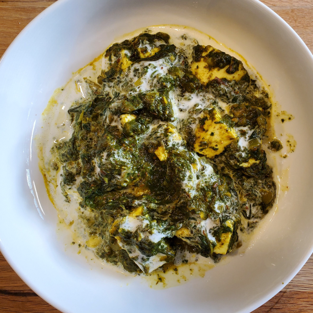 white bowl with palak paneer with cream